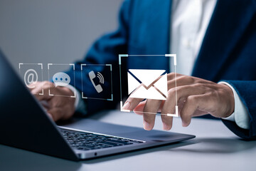 Contact us or Customer support hotline. Businessman using laptop with contact icons (email, address, live chat, telephone) on virtual screen.