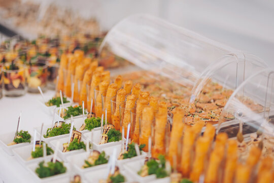 churro bar at wedding reception, churros at event, close up. Various snacks on table, banquet food. buffet table served with exotic food. delicious festive buffet with canapes and different meals 