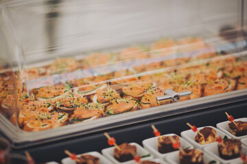 A set of canapes and snack at a banquet with table. Catering table, decorated banquet with variety of with different food snacks and appetizers on corporate birthday party event or wedding celebration