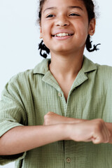 Empowered young african american boy raising fist in front of white background