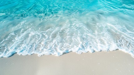 A sandy beach with white sand and light blue clear sea water.