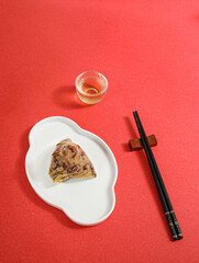 Traditional Chinese Dragon Boat Festival food dumplings and tea on a red table
