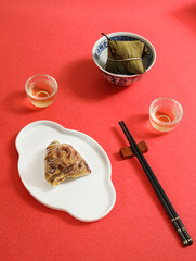 Traditional Chinese Dragon Boat Festival food dumplings and tea on a red table
