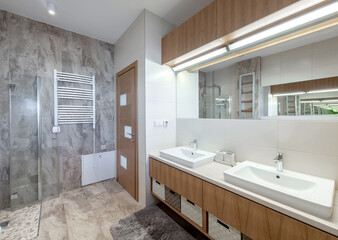 Bright Elegant Modern Bathroom Interior Design of White Sink, Mirror, Heater. Bathroom Accessories, Gray Tile Walls, LED Light.