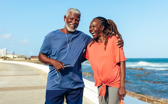 Happy elderly couple enjoying a joyful walk by the seaside