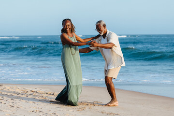 Senior African American couple enjoying a dance on the beach