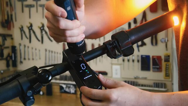 Repairing an electric scooter in a workshop. A close-up shot of a master disassembling a scooter with an electric screwdriver.