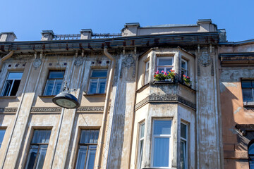 Bay windows decorated with potted flowers on an old stone house