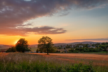 Meadows with sunset in Krusne mountains in evening in Nova Ves v Horach village