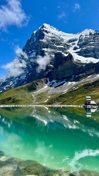 Eiger northface over a reflecion mountain lake in switzerland