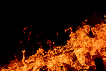 Obraz premium A dramatic image of a fierce fire burning intensely against the dark night sky. The bright orange and yellow flames highlight the raw energy and destructive power of the blaze. Copy space available.