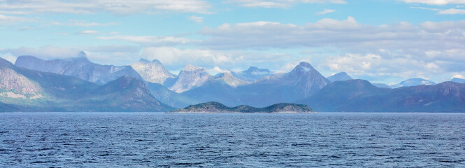 Panoramic view of the majestic Lofoten Islands, featuring rugged mountains and clear blue skies reflected in the calm sea. A stunning and serene natural landscape. Lofoten Islands, Norway