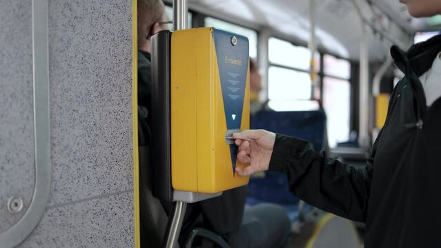 A woman pays with a card for travel on public transport. Concept of travel, trips and public movements.