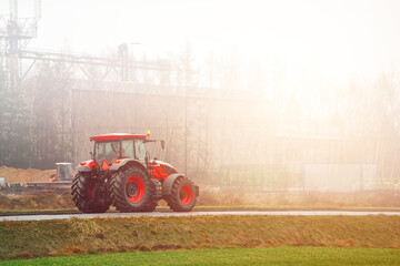 Rural farm tractor working on misty overcast morning