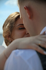 Fototapeta premium bride hugs the groom's shoulders, outdoor wedding ceremony 