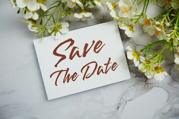 Save the Date card with flower bouquet decoration top view on marble background