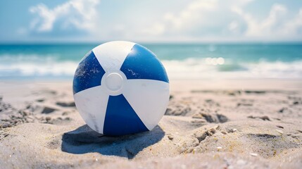 Obraz premium Close Up of a navy blue and white Beach Ball on sandy Beach. Summer Vacation Background