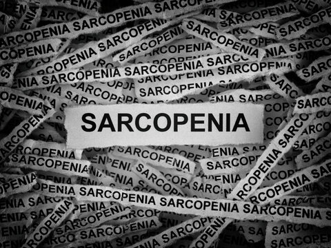 Strips of newspaper with the words Sarcopenia typed on them. Black and white. Close up.