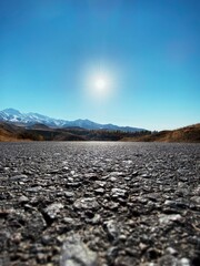 Enjoy a tranquil drive on an empty road with stunning mountain scenery during sunrise