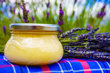 Jar with honey and lavender flowers.