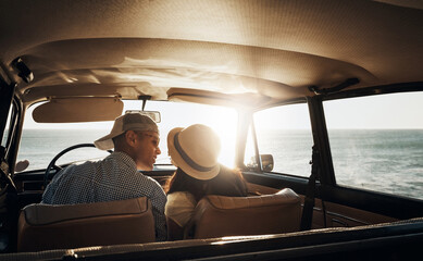 Fototapeta premium Couple, car and driving with back by ocean for travel, smile or holiday for view of sunset in summer. Man, woman and road trip with connection, kiss and love for bonding in sunshine at beach in Spain