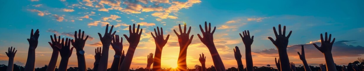Silhouettes of Raised Hands at Sunset During an Outdoor Gathering