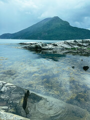 Gloomy Nordic fjords and rocks. Vertical photo with mystic landscape in Norway.