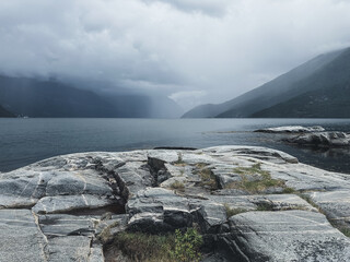 Gloomy Nordic fjords and rocks. Horizontal photo with mystic landscape in Norway.