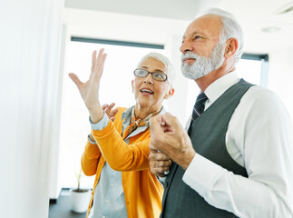 Obraz premium business meeting businesswoman woman elderly senior office presentation whiteboard businessman man teamwork colleague seminar businessperson mature gray hair discussion