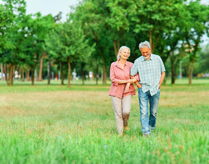 woman man senior couple happy retirement together elderly active love vitality bonding park outdoor walking holding hands leisure park fun smiling old