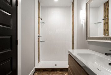 Minimalist Bathroom With Modern Fixtures, White Tiles, And A Large Mirror
