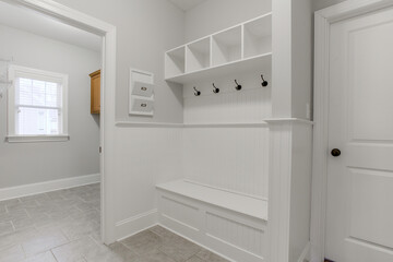 Minimal Mudroom With Bench, Hooks, Storage, And Adjacent Laundry Space