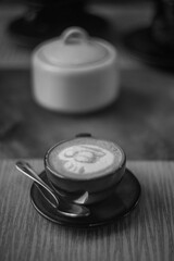 Cafe Latte in a small mug on a saucer with a little spoon