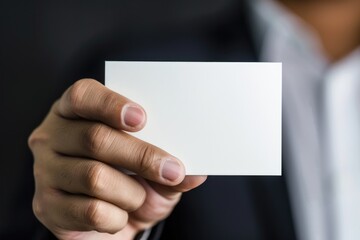 A businessman holds a white card, likely an invitation or announcement