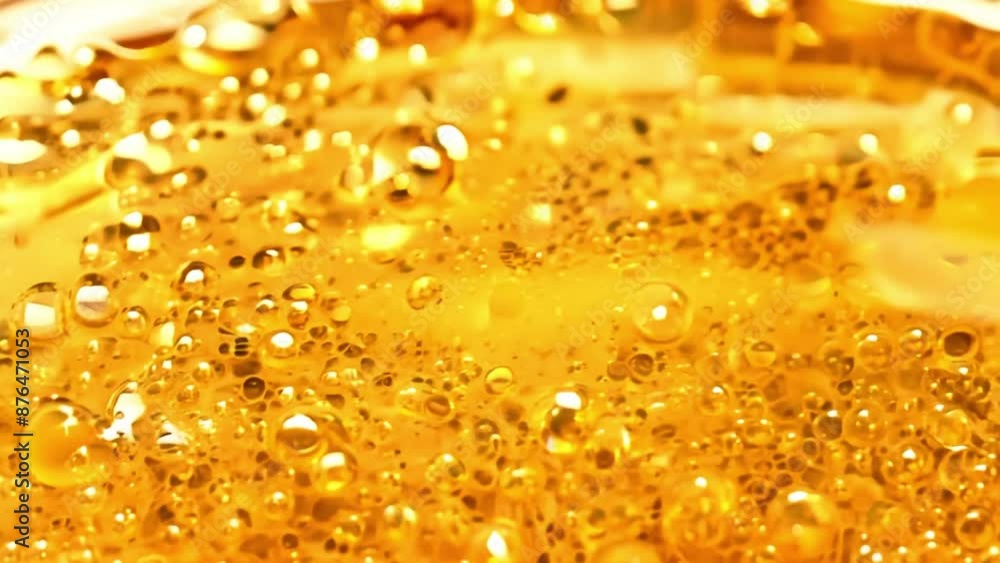 Poster a close up of a yellow liquid with bubbles in it. the bubbles are small and scattered throughout the