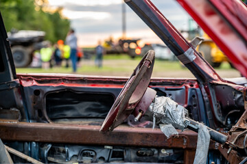 Selective focus on the interior steering column and wheel on a modified car for a demolition derby