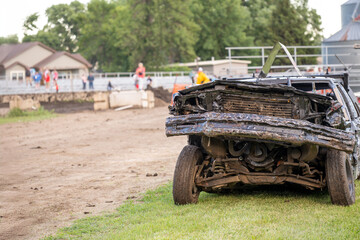 Selective focus on the front end of a wrecked car after impact in a demolition derby.