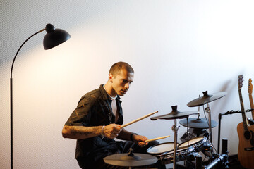 Mixed race musician playing drums in music studio