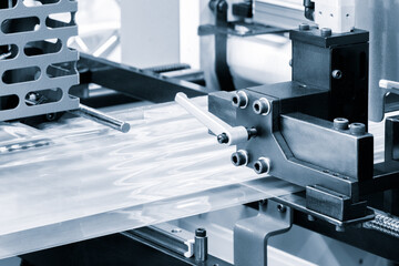 Automatic polyethylene plastic bag production machine with lighting effect. Close-up of the roller of the plastic bag production machine in the light blue scene. product packaging concept