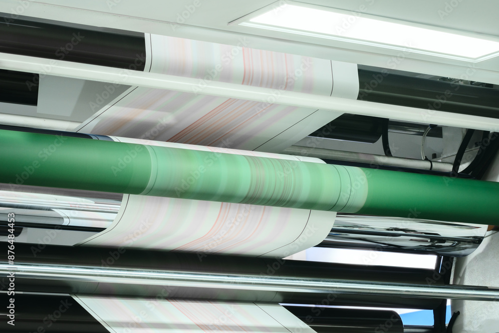 Aufkleber a roll of paper being printed on a machine. the rolls of paper are stacked on top of each other, and