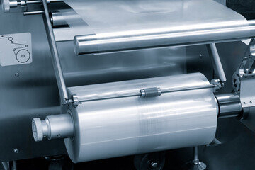Automatic polyethylene plastic bag production machine with lighting effect. Close-up of the roller...
