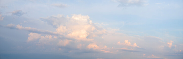 Obraz premium A pink and white cloudless sky with a pinkish hue. The sky is filled with clouds and the sun is setting