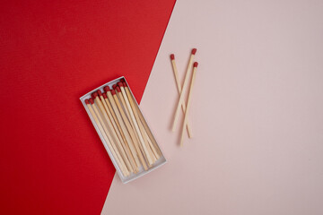 Box with new matchsticks on color background. Scattered wooden matches without a box close-up. Design
