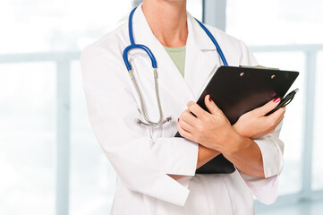 Close up of doctor clutching a clipboard