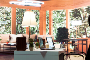 Empty home office belonging to a small business owner with data sales reports on laptop, annual information and invoices for accounting work. Finance and economy budget balance.