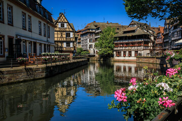 Ornate traditional half timbered houses with blooming flowers along the canals in the picturesque Petite France district of Strasbourg, Alsace, France