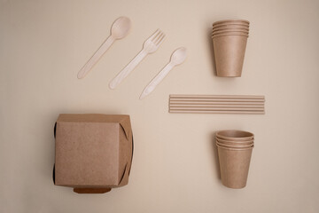 Kraft paper tableware: cups, food boxes, isolated on a light background. A set of various disposable tableware. Recycling and zero waste concept. Mock up