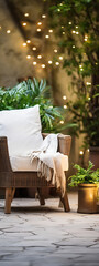A comfortable and inviting wicker chair with a soft cushion and a warm blanket, perfect for relaxing in a cozy outdoor space surrounded by lush greenery and twinkling lights.