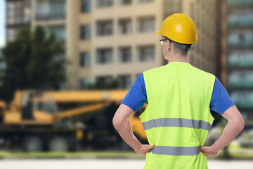 Man wearing safety equipment at construction site, back view. Space for text