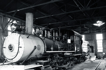 Black and white image of an old coal-burning train engine.
